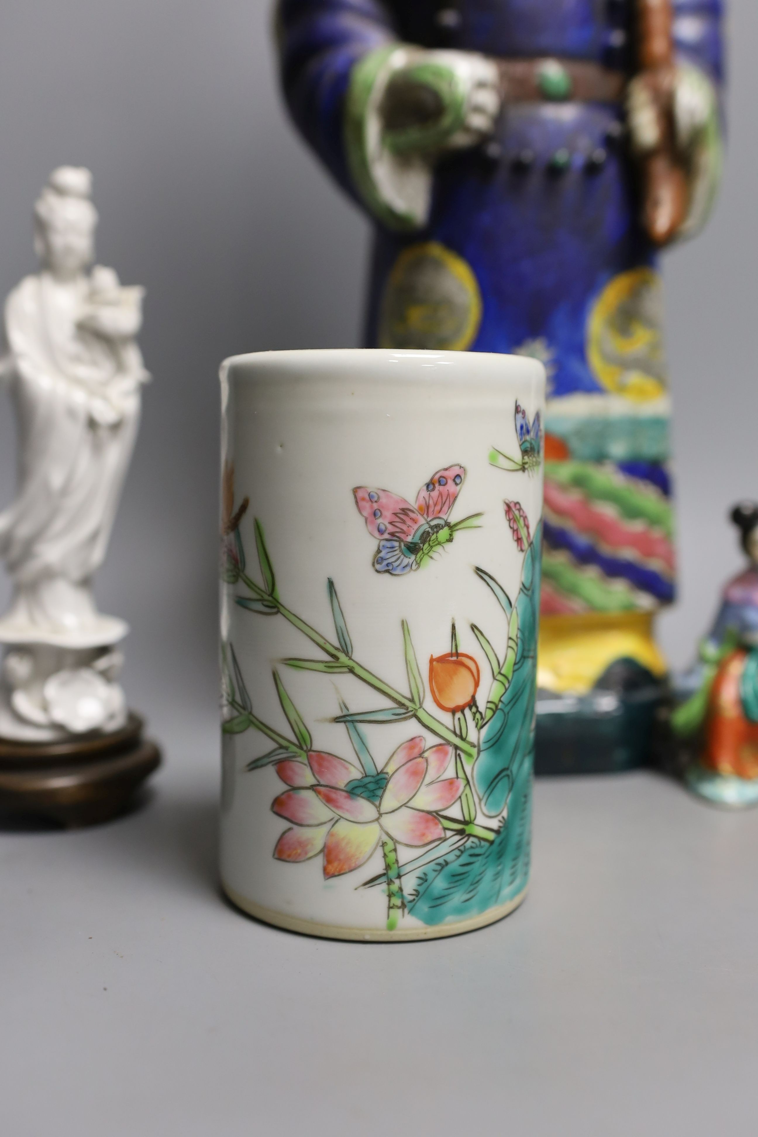 A Chinese brush pot, a pair of blanc de chine deities, a famille rose early 20th century figure, and a Kangxi emperor brush holder (5) - 45cm tall